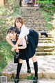 Two young women in school uniforms posing for a picture.