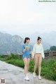 A couple of women walking down a road holding hands.