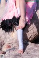 A little girl with a cast on her leg sitting on a rock.