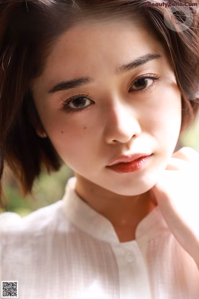 A woman in a white shirt is posing for a magazine cover.
