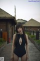 A woman in a black bathing suit posing for a picture.