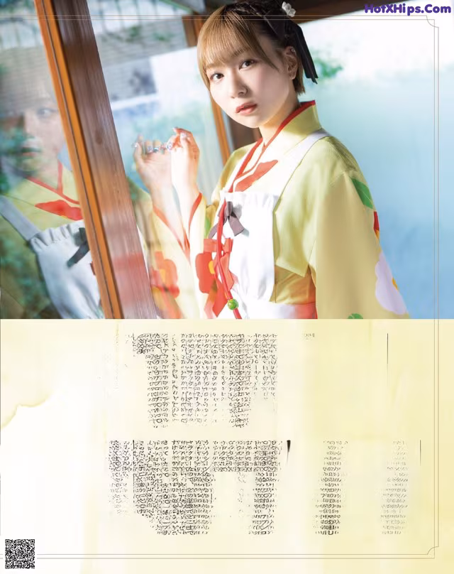 A woman in a yellow kimono standing in front of a window.