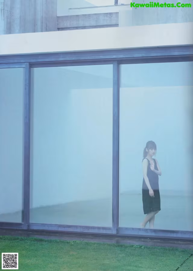 A woman standing in front of a glass wall.