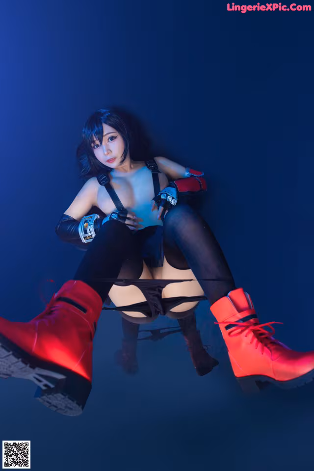 A woman in a black and red outfit sitting on a blue background.